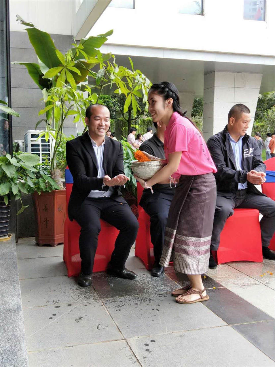 老撾駐廣西留學(xué)生代表將浸有花瓣的香水灑客人的手上，表示對嘉賓的美好祝福（圖一）